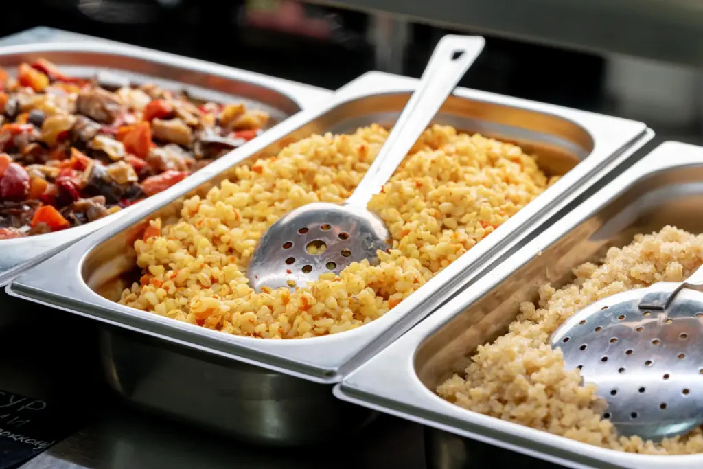 Buffet metal trays with bulgur rice and vegetable stew