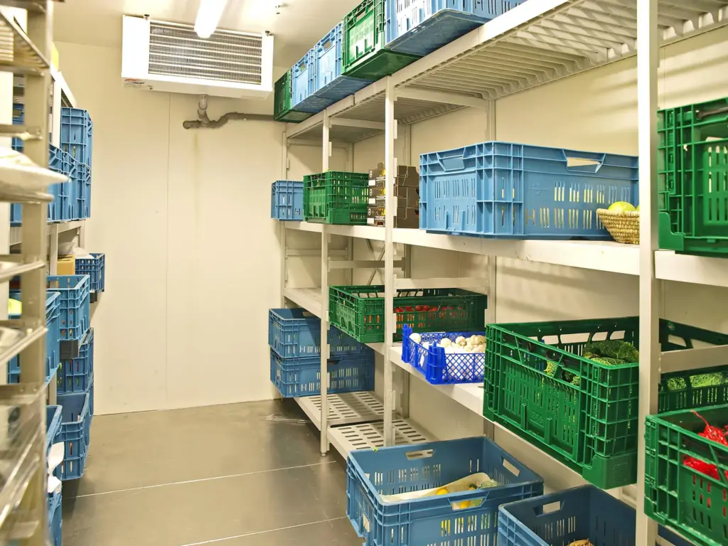 Commercial walk in cooler with shelves holding plastic produce crates