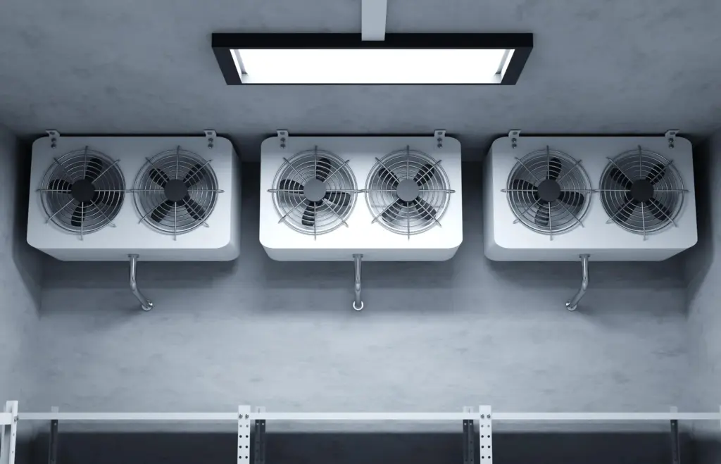 Industrial refrigeration unit with dual fans mounted on a concrete wall