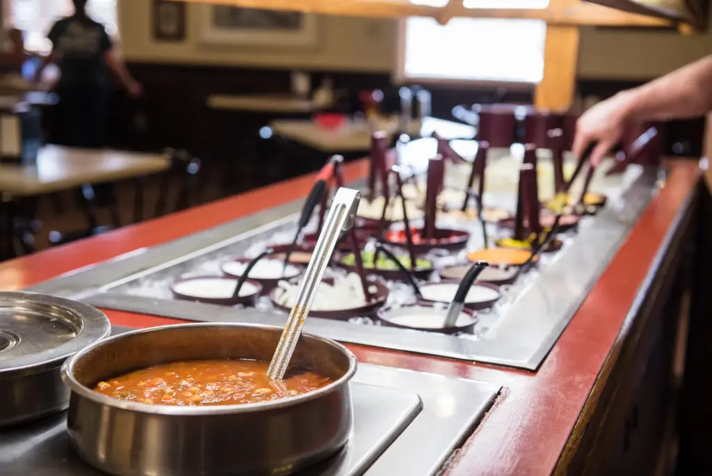 Restaurant salad bar with soup and assorted chilled toppings