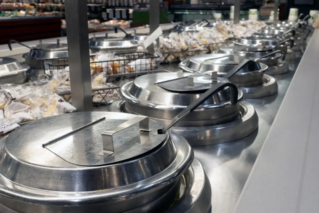Row of stainless steel soup warmers in cafeteria buffet line